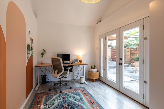 office space featuring light hardwood / wood-style flooring, lofted ceiling, and french doors