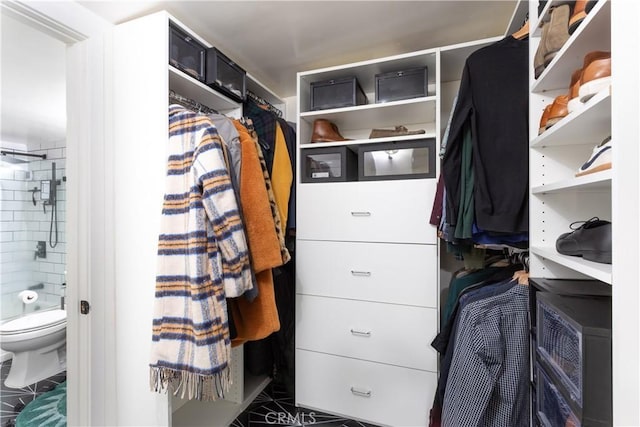 walk in closet featuring dark tile patterned floors