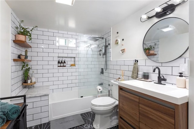 full bathroom with tile walls, toilet, vanity, and tiled shower / bath