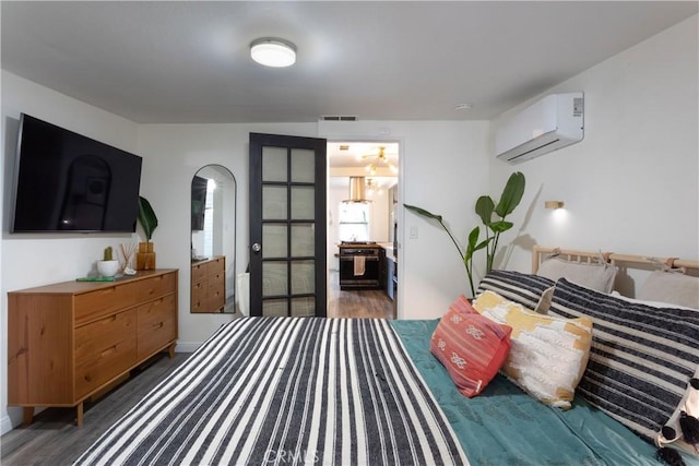 bedroom with dark wood-type flooring and a wall unit AC