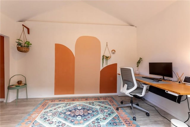 home office with wood-type flooring and vaulted ceiling