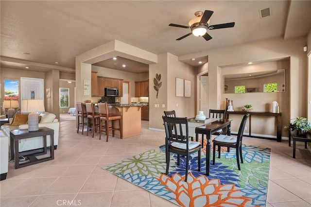 dining space with light tile patterned floors and ceiling fan