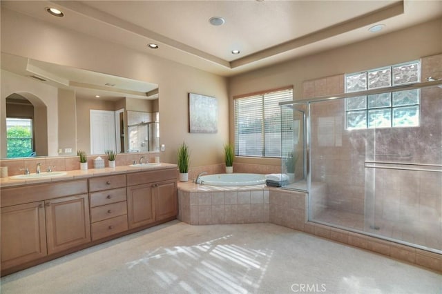 bathroom with vanity, plenty of natural light, and a raised ceiling