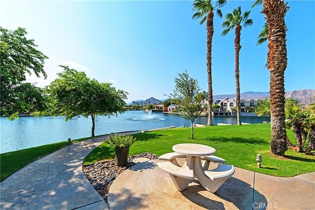 view of community with a water view and a lawn