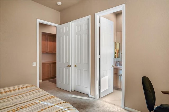 unfurnished bedroom with light colored carpet and ensuite bathroom