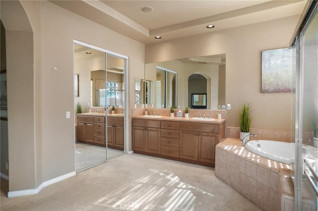 bathroom featuring vanity and tiled tub