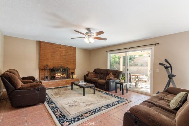 living room with ceiling fan, a fireplace, and tile patterned flooring