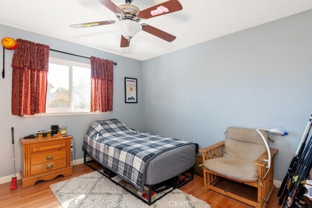 bedroom with ceiling fan and light hardwood / wood-style floors