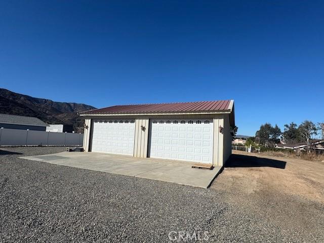 detached garage featuring fence and a mountain view