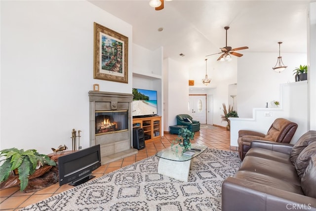 living room with high vaulted ceiling, a glass covered fireplace, ceiling fan, and light tile patterned floors