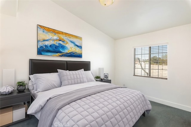 bedroom featuring lofted ceiling, dark carpet, and baseboards