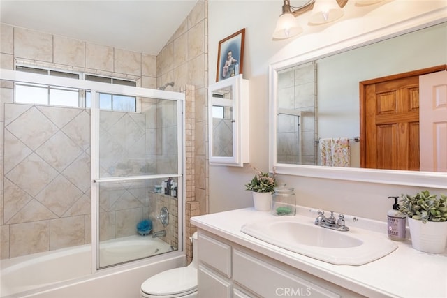 bathroom with shower / bath combination with glass door, vanity, and toilet