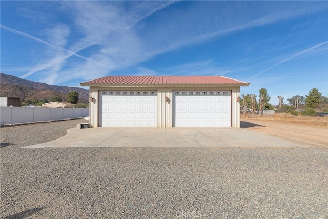 detached garage featuring fence and a mountain view