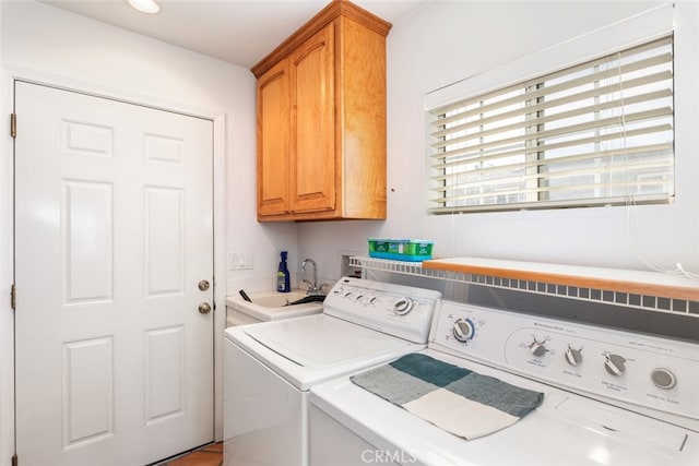 washroom featuring cabinet space, washer and clothes dryer, and a sink