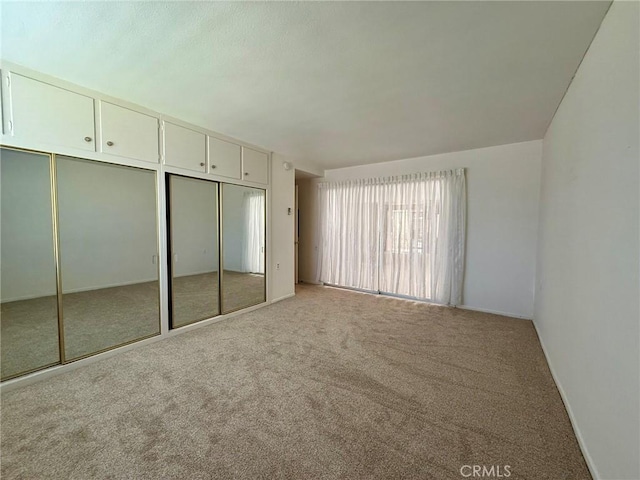 unfurnished bedroom featuring light carpet