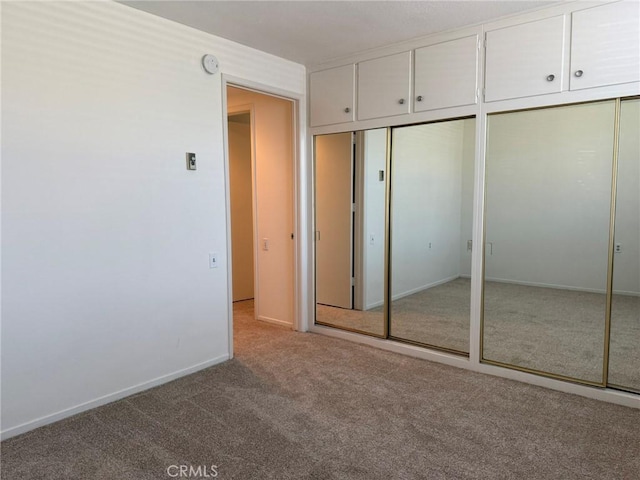 unfurnished bedroom with carpet floors and multiple closets