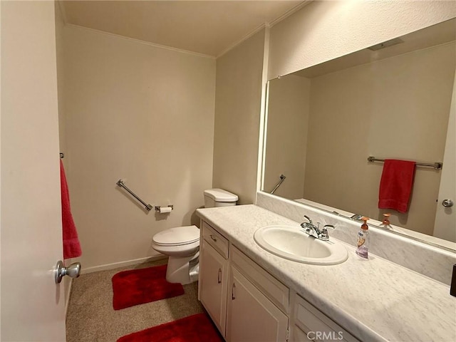 bathroom with vanity, crown molding, and toilet