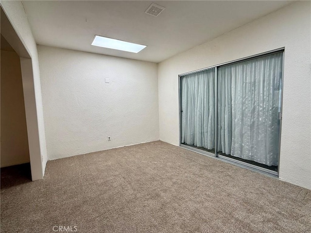 carpeted spare room with a skylight