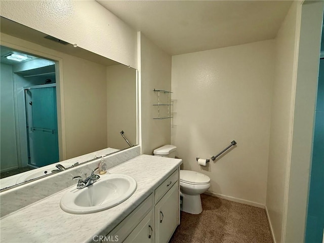 bathroom featuring vanity, toilet, and a shower