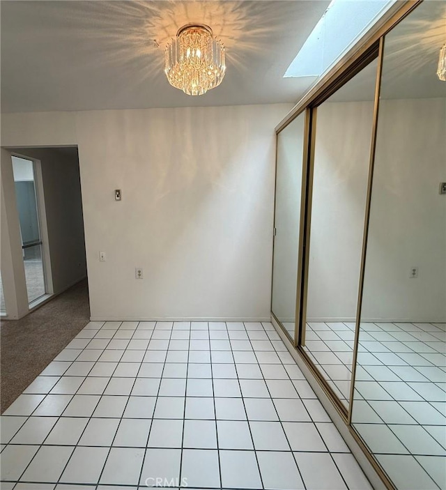 interior space featuring a chandelier, a skylight, and light tile patterned floors