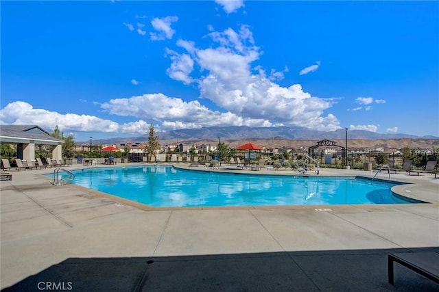 view of swimming pool with a mountain view and a patio