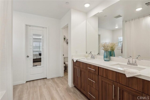 bathroom with vanity, hardwood / wood-style floors, and toilet