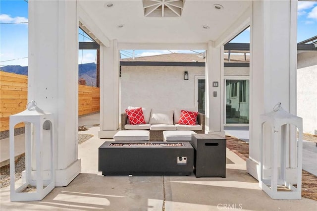 view of patio with an outdoor living space with a fire pit