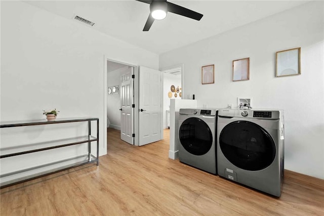 laundry area with ceiling fan, washer and clothes dryer, and light hardwood / wood-style flooring