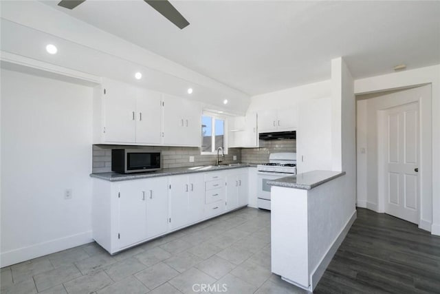 kitchen with decorative backsplash, sink, white cabinetry, and white gas stove