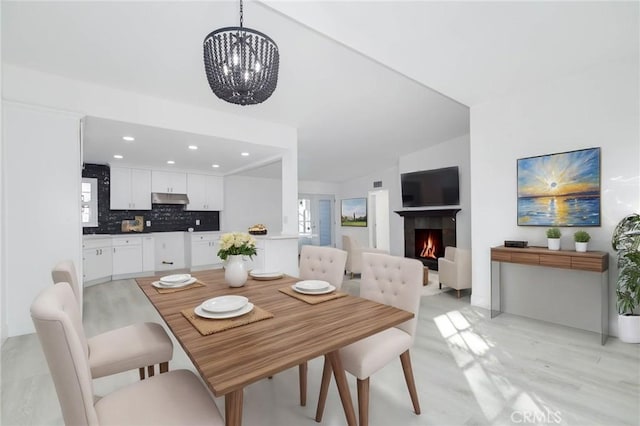 dining room featuring an inviting chandelier, lofted ceiling, and light hardwood / wood-style flooring