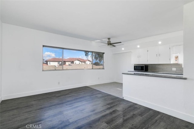 unfurnished living room with ceiling fan and dark hardwood / wood-style floors