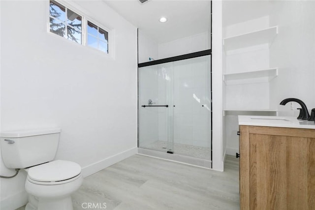 bathroom with toilet, vanity, wood-type flooring, and a shower with door