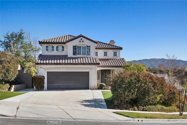 mediterranean / spanish house featuring a garage and a mountain view