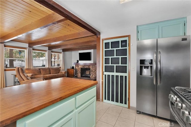 kitchen with light tile patterned flooring, appliances with stainless steel finishes, beamed ceiling, butcher block counters, and wooden ceiling