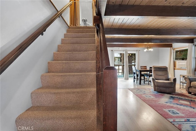 staircase featuring a notable chandelier, wood-type flooring, wooden ceiling, and beam ceiling