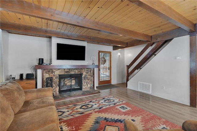 living room featuring beamed ceiling, wood-type flooring, wood ceiling, and a fireplace