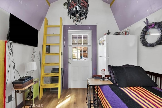 interior space featuring hardwood / wood-style flooring, vaulted ceiling, and white refrigerator