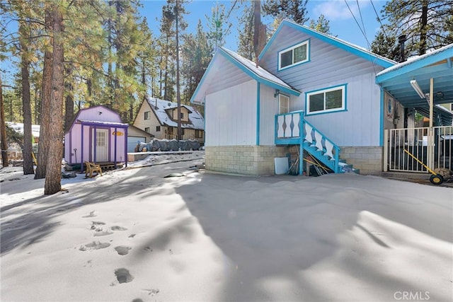 rear view of property with a storage shed