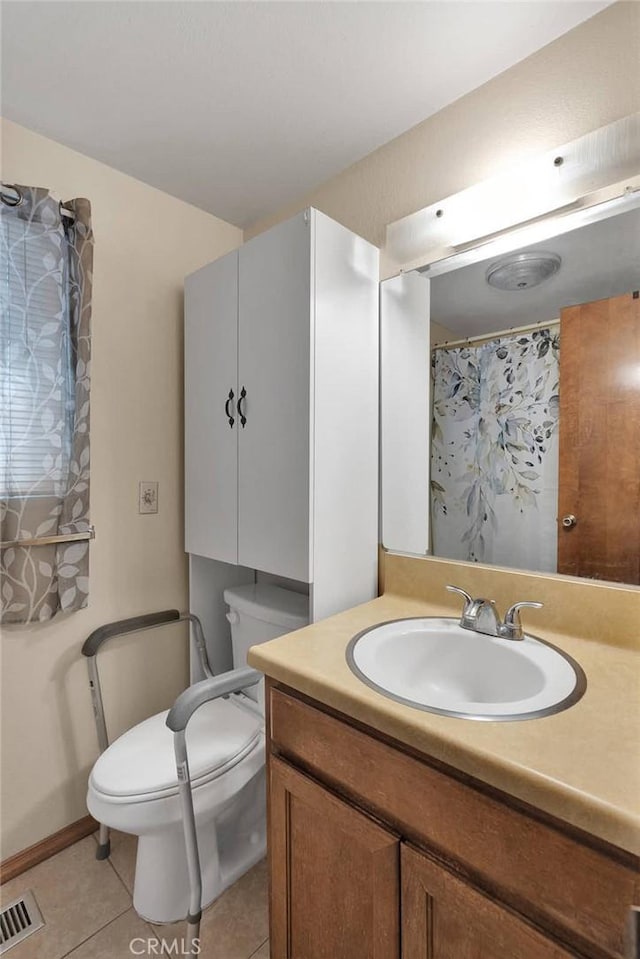 bathroom featuring tile patterned flooring, vanity, and toilet