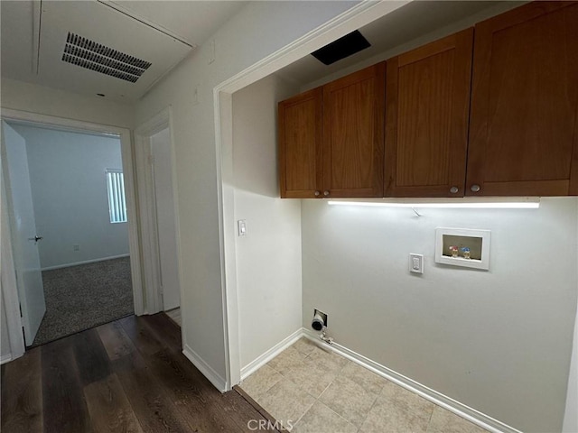 laundry area featuring electric dryer hookup, hardwood / wood-style flooring, hookup for a washing machine, and cabinets