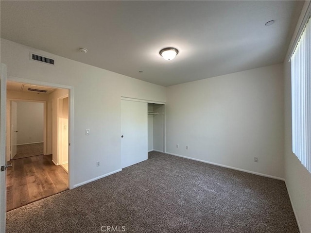 unfurnished bedroom featuring a closet, carpet floors, and multiple windows