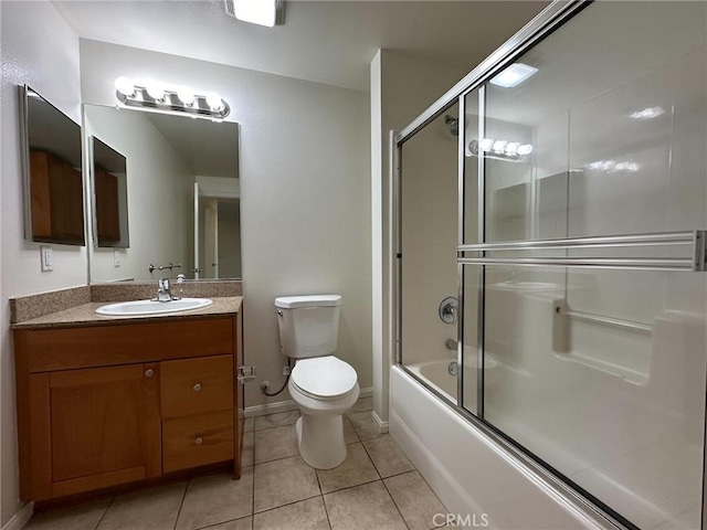 full bathroom featuring toilet, bath / shower combo with glass door, tile patterned flooring, and vanity