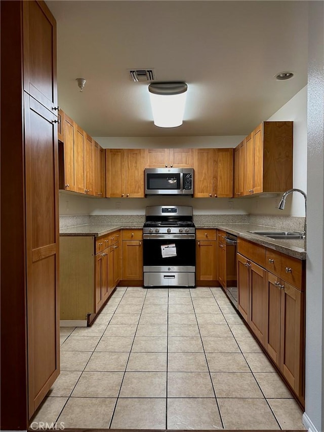 kitchen with light tile patterned floors, stainless steel appliances, and sink