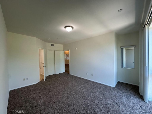 unfurnished bedroom with dark colored carpet