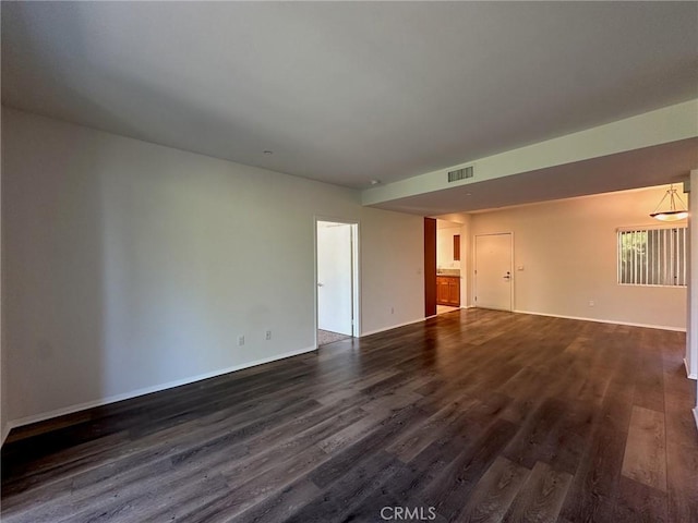 empty room with dark hardwood / wood-style flooring