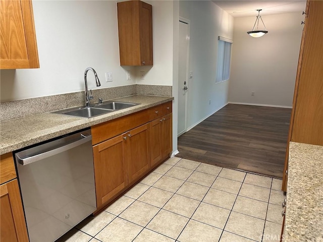 kitchen featuring light tile patterned floors, pendant lighting, stainless steel dishwasher, and sink