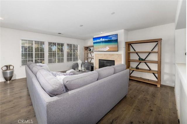 living room with dark hardwood / wood-style floors and a tiled fireplace