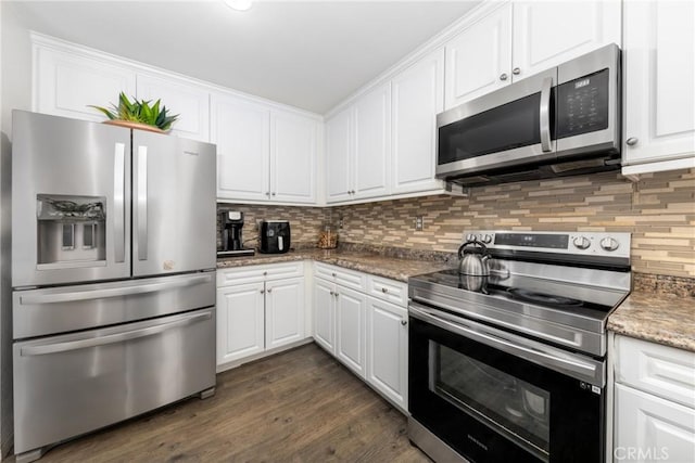 kitchen featuring appliances with stainless steel finishes, white cabinetry, dark hardwood / wood-style flooring, backsplash, and stone counters