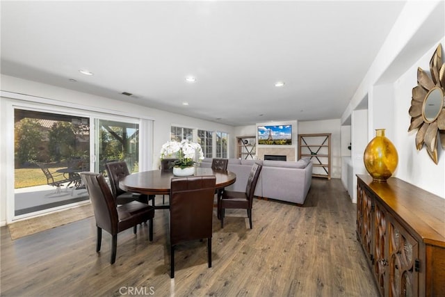 dining room featuring a fireplace and dark hardwood / wood-style flooring