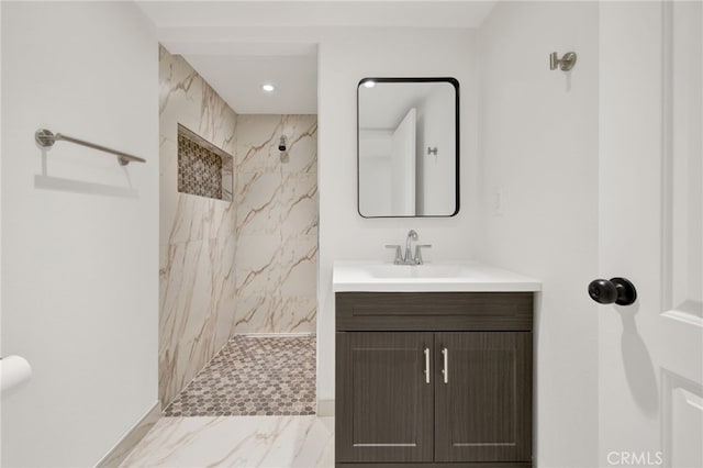 bathroom with vanity and a tile shower